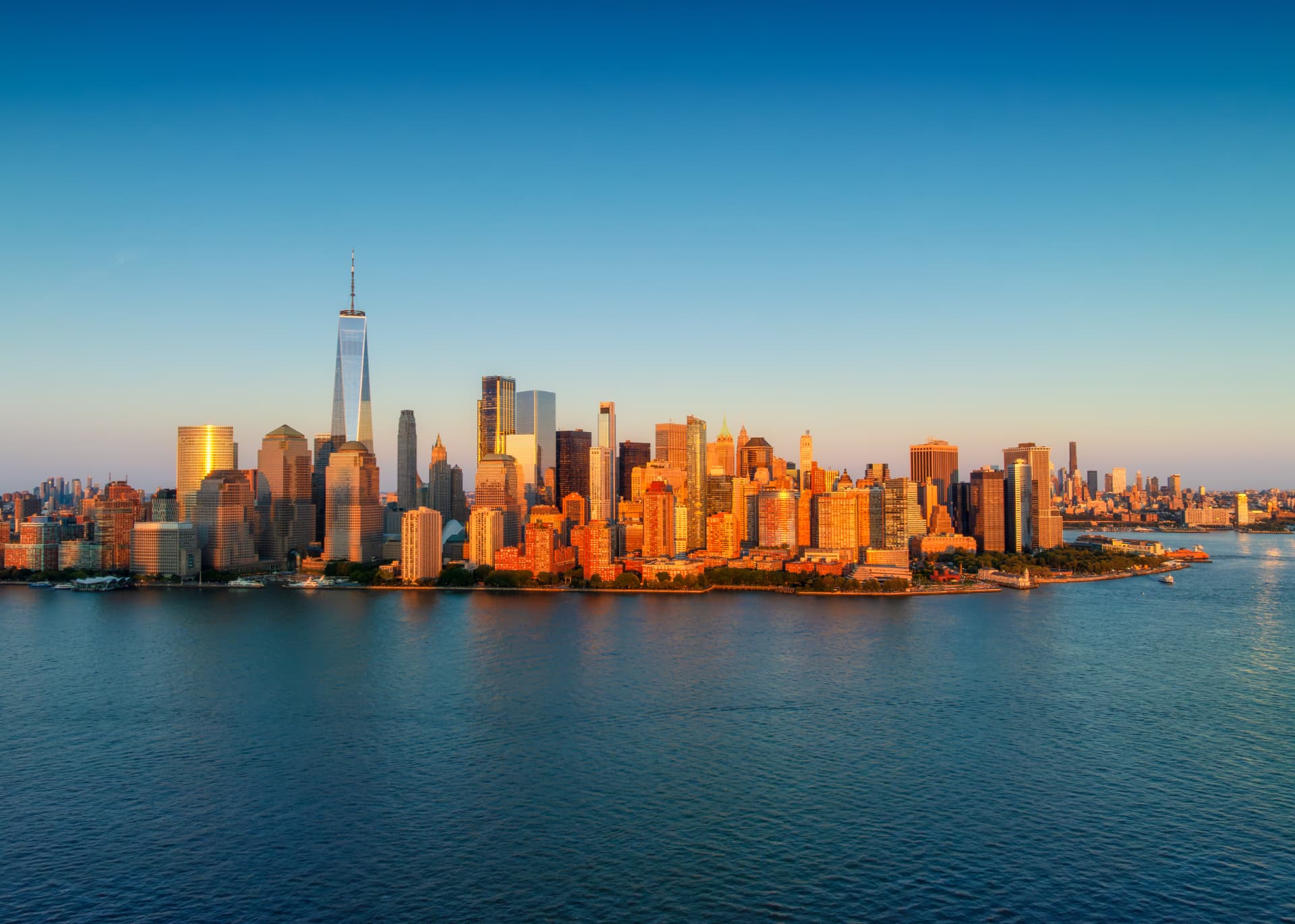 Aerial view of the Lower Manhattan skyline at sunset from the harbor